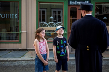 Barn som snakker med en skuespiller kledd ut som politi